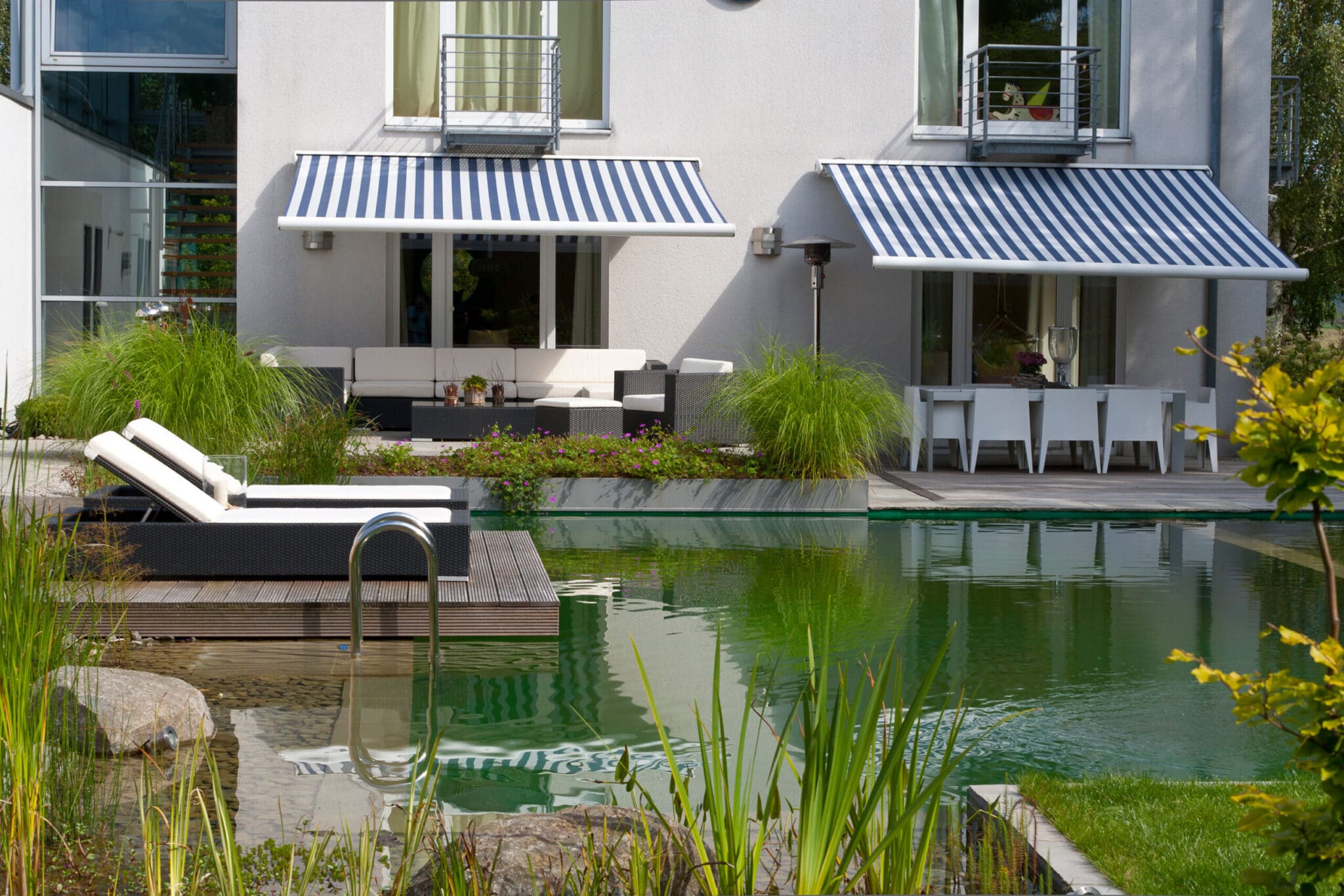 loc933-018-s Moderne Gartenlandschaft mit einem Pool, Liegen und einem Essbereich im Freien.